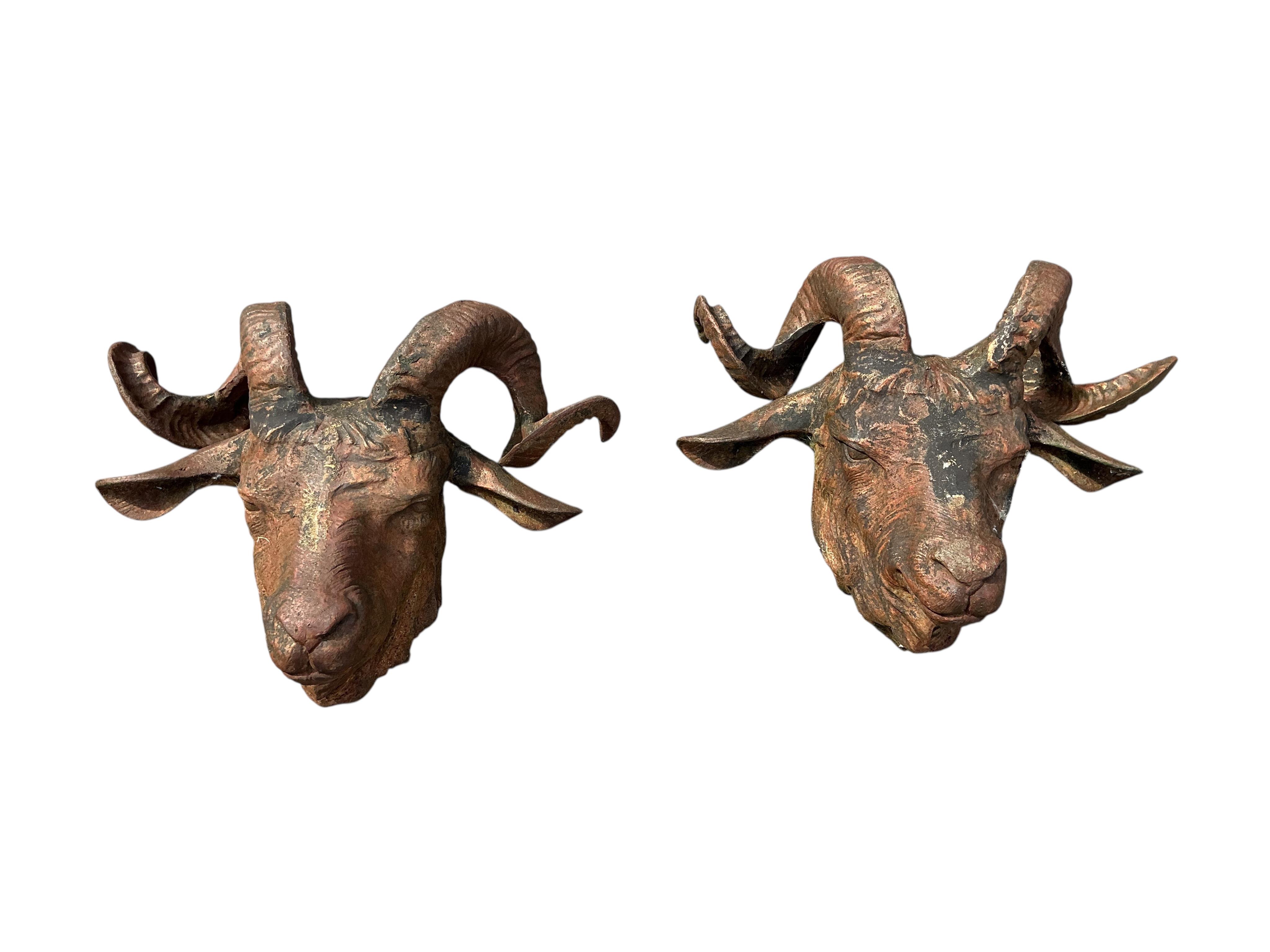 A set of four cast iron ram's head garden wall appliqués, width 48cm, height 36cm